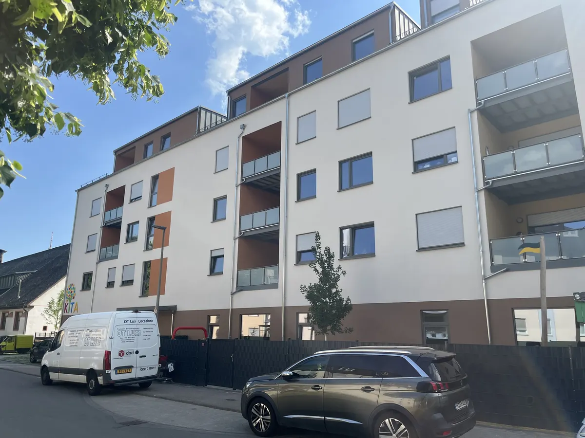 Straßenfassade des Quartiers St. Ambrosius in Trier mit farbigen Akzentfeldern und Balkonen