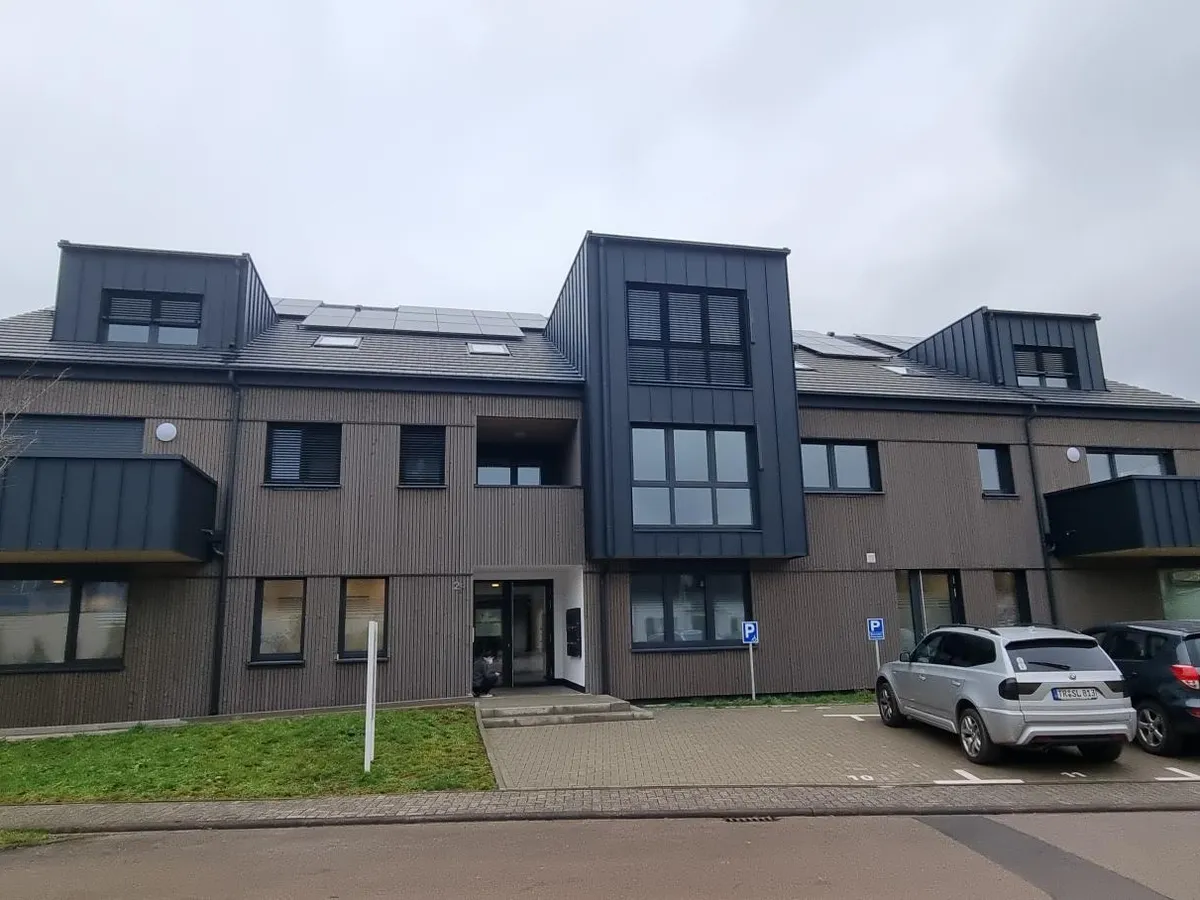Ärztehaus in Tawern mit Holzfassade und Gauben, Frontansicht mit Eingang