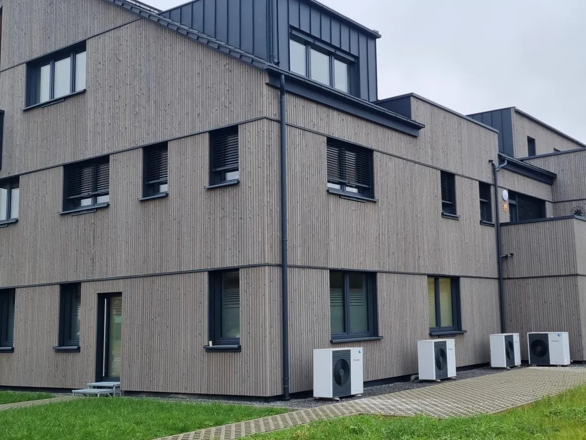Gartenseite des Ärztehauses in Tawern mit Holzfassade und Wärmepumpen